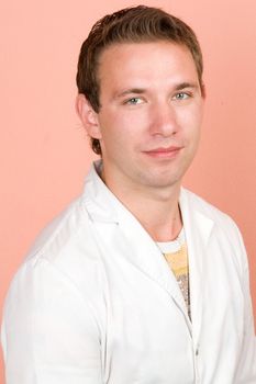 young smiling man in a white doctor's smock.