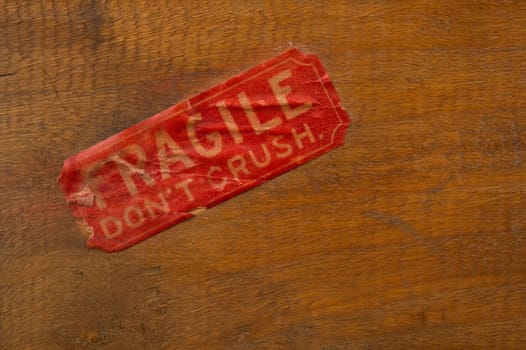 Image of an antiqued fragile label on wood background