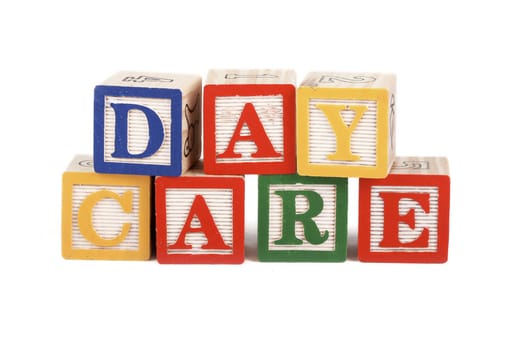 Alphabet blocks lined up to spell the word daycare isolated on white