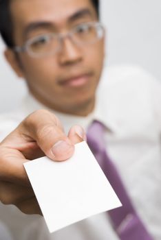 Blank card holding by Asian business man.