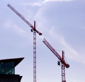 Constrcution Cranes on site silhouetted by the light at dusk in Cardiff Wales UK