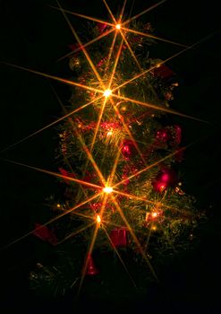 a christmas tree with electric candles on the black background