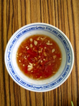 a top view for a small bowl of chilies sauces, serving with food