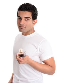 A man holds a bottle of cologne, aftershave or men's fragrance in his hand
