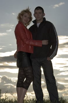 Young family against a sunset and the sky with clouds