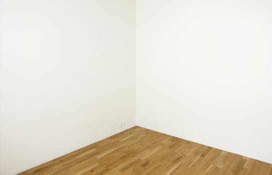 Blank white wall in a clean room with wooden floor - insert your own design on the wall