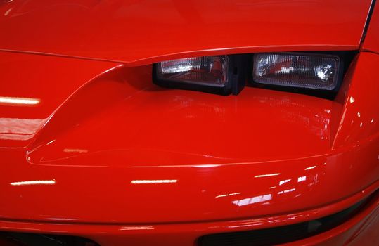 Fast red sports car close-up with headlights