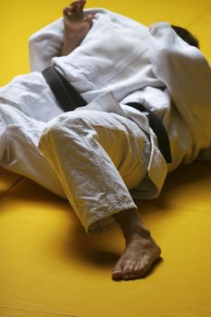 Two judo fighters wrestling hard in a tournament - some grain visible
