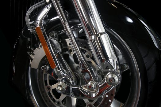 Close up of a chrome rim and wheel on a big motor bike