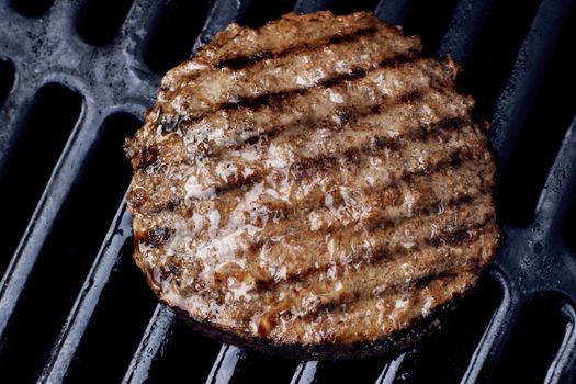 Juicy grilled hamburger on the barbecue with grillmarks