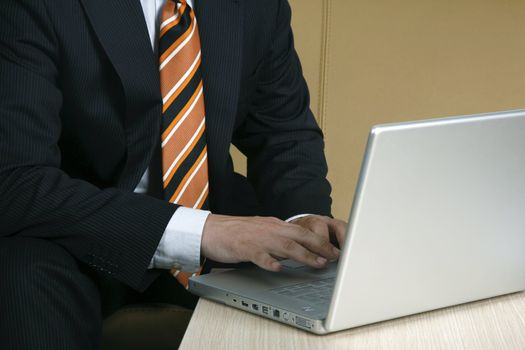 Well dressed business man typing on a laptop - business  on the go