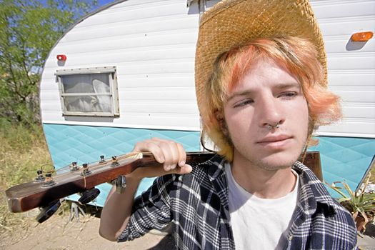 Young Man with Bright Red Hair and a Guitar in front of Trailer
