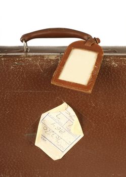 Old and worn retro suitcase close-up with travel nametag