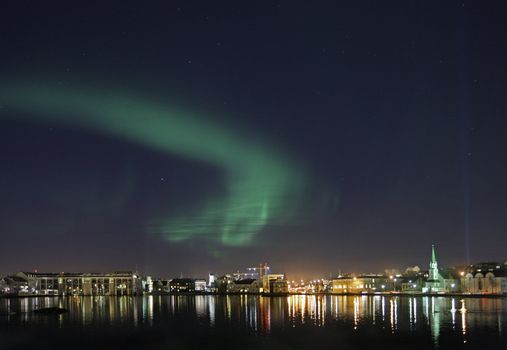 Beautiful scene from dowtown Reykjavik with aurora borealis in the sky above - Reykjavik City hall is the building on the far left and to the right of city hall is Althingi