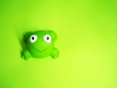 a frog toy on a green background