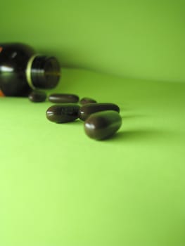 a bottle of pills on a green background