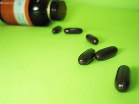 a bottle of pills on a green background