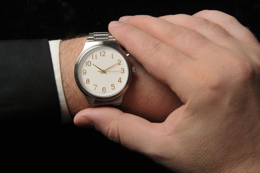 Business man looking at watch. Black Background