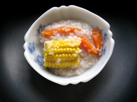 a bowl of porridge with corns and carrot