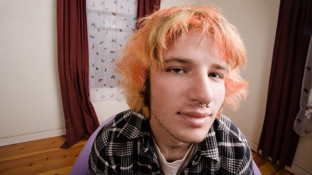 Closeup of a Young man with Bright Hair in a Bare Room