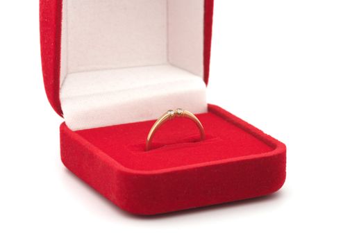 Red gift box with a gold ring close up.