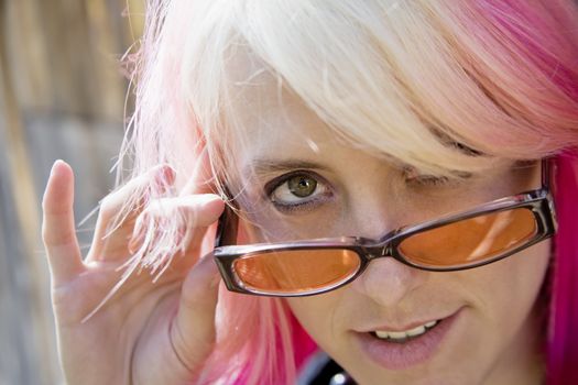 Pretty Young Woman with Brightly Colored Hair Looking Over the Top of her Sunglasses