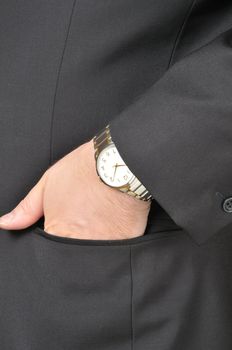 A man in a business suit, put his hand to the clock in the pocket of his jacket