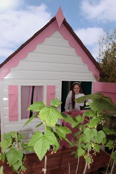 a young girl looking out of a playhouse window