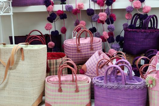 straw bags of various colors in a market