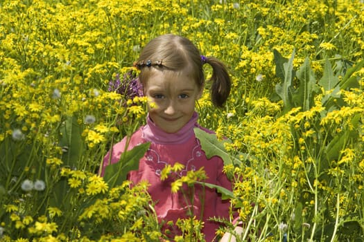 The girl in a pink dress plays yellow colors