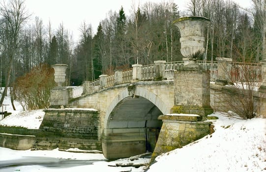 Old stone brige with vases in winter