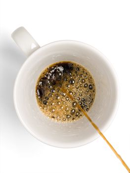 Fresh coffee being poured into a coffee cup on a white background.