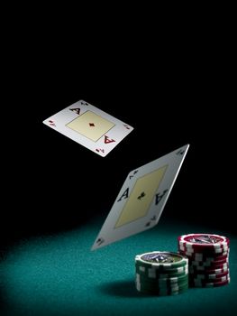 Two aces flying over a green felt with three piles of different colors chips.