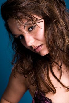 Fresh brunette girl in purple lingerie on blue