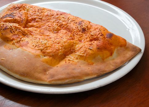 Delicious hot Calzone pizza  On a plat. Close-up