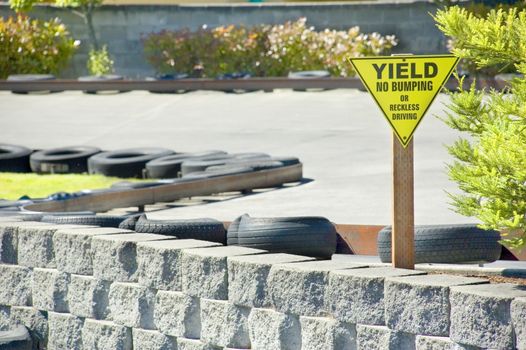 A Yield Sign warns drivers against bumping or reckless driving on a go cart track.