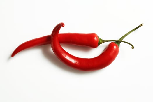 Perfectly fresh red hot peppers on white. The file includes a clipping path.  Professionally retouched high quality image.