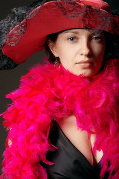 Beautiful woman in pink feathers and hat. Close-up view