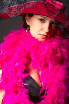 Beautiful woman in pink feathers and hat. Close-up view