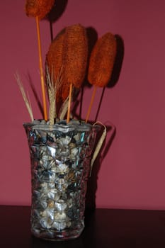 florero lleno de piedras con flores secas adornando