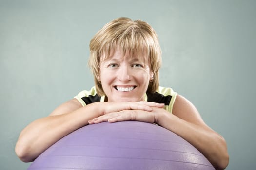 Portrait of a Pretty Woman Leaning on an Exercise Ball