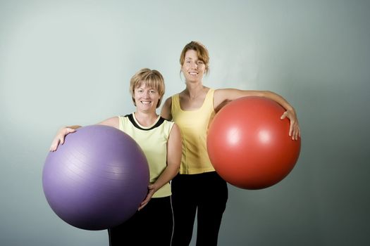 Two Physically Fit Women Posing With Exercise Balls