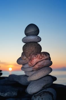 A pile of the stones on the seashore at sunset