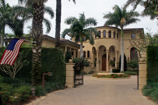 A very large home with pillars and a flag.