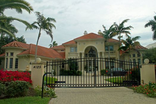 A very large home with pillars and a driveway.