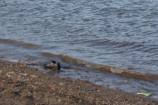 Abstract image - lost shoe on bank of the river