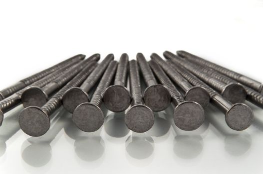 Close and low level of the heads of a number of steel nails arranged in a repetitive pattern.