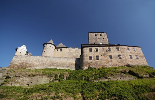 Kost Castle - large Gothic castle - is located in the Ji��n District of the Czech Republic. "Kost" is "bone" in Enhlish - as hard as  bone. 
In Northern Bohemia, specifically the region Bohemian Paradise lies Kost Castle, first proposed by Benes von Wartenberg in 1349 as a possible construction site. It was completed by his son Peter von Wartenberg and since then it has not been changed and is still in good repair.
The castle is known for its so-called "White tower". In about 1414 the family of Zaj�c von Hasenburg moved there; later the family of Schellenberg (1497 - 1524), Lobkowicz (till 1576) and others; in this time some more buildings were built near the castle and joined to it.
Unlike most other castles in Bohemia, it does not lie on a hill, but on a spit between two brooks. Another peculiarity is the tower, which has a trapezoid-like ground-plan. Like in some other cases, the reason was that if an artillery shell was fired, it would not hit the wall at a right angle (the angle of greatest possible damage).

