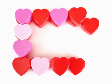 Assorted heart shapes in red, pink and purple arranged with room for text against a white background.