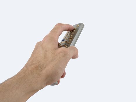 A male hand holds a remote control for an electronic media device. Over a white background.